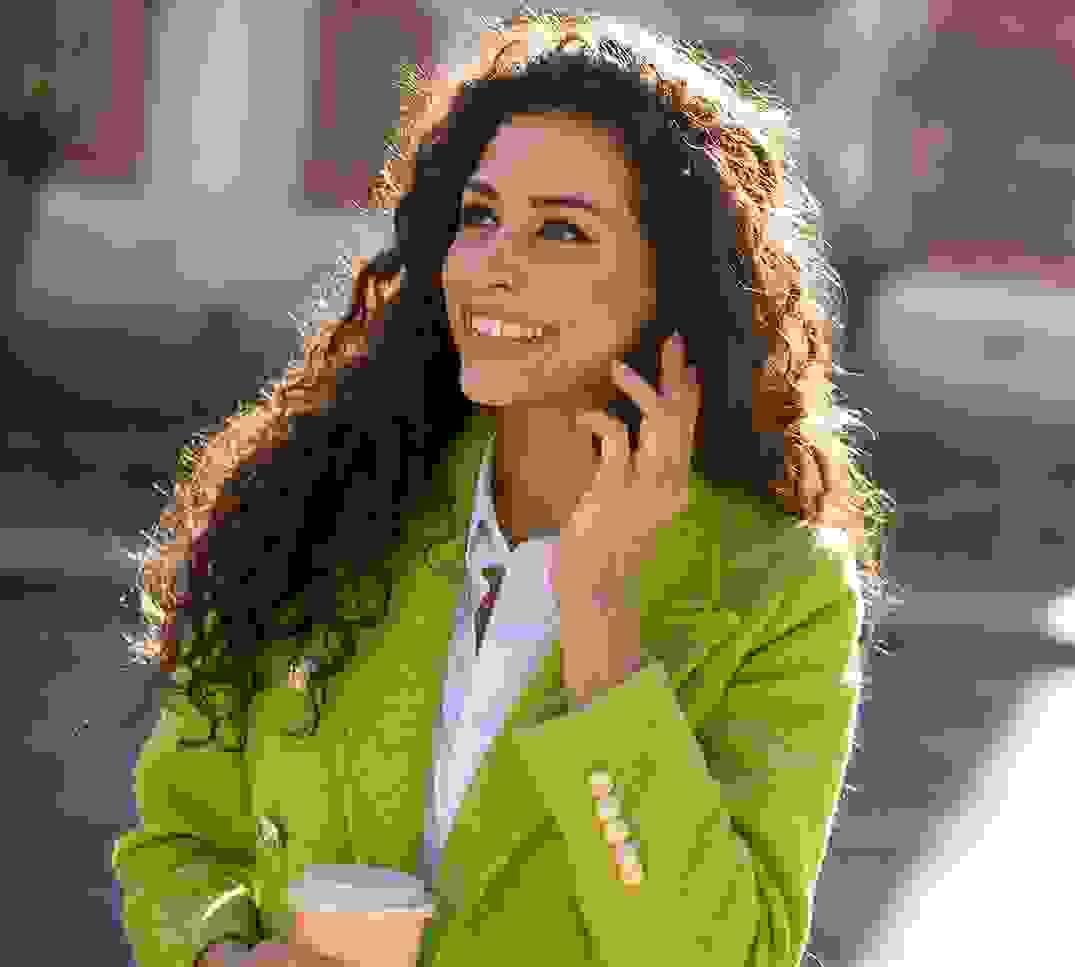 Donna sorridente al telefono all’aperto – consulenza personalizzata sulle modifiche dell’assicurazione malattia 2025/2026