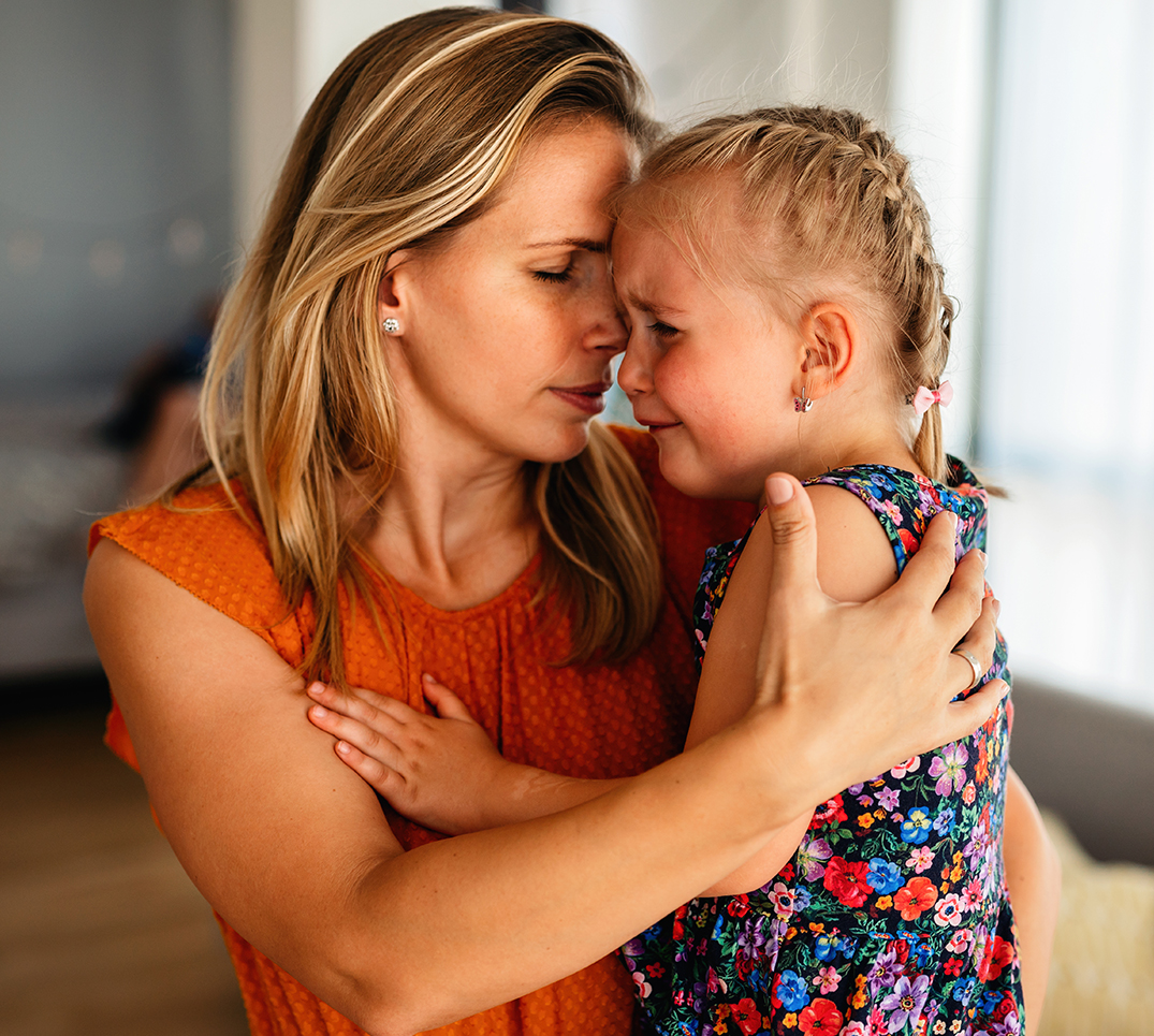 Un adulto consola un bambino che piange. Dopo un incidente dentale non solo l'aiuto medico, ma anche il sostegno emotivo è determinante.