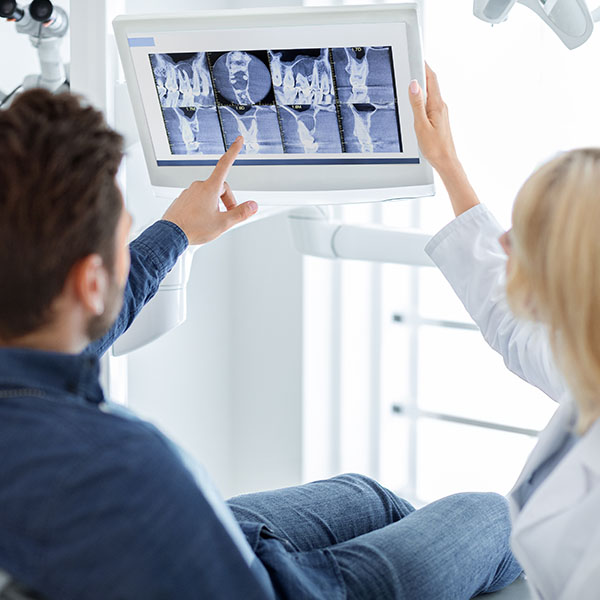 Kosten besprechen Zahnröntgen Implantat Besprechung von Röntgenbildern: Vor grösseren Eingriffen wie Implantaten oder Zahnsanierungen wird der Zustand der Zähne genau analysiert. Solche Behandlungen können hohe Kosten verursachen.