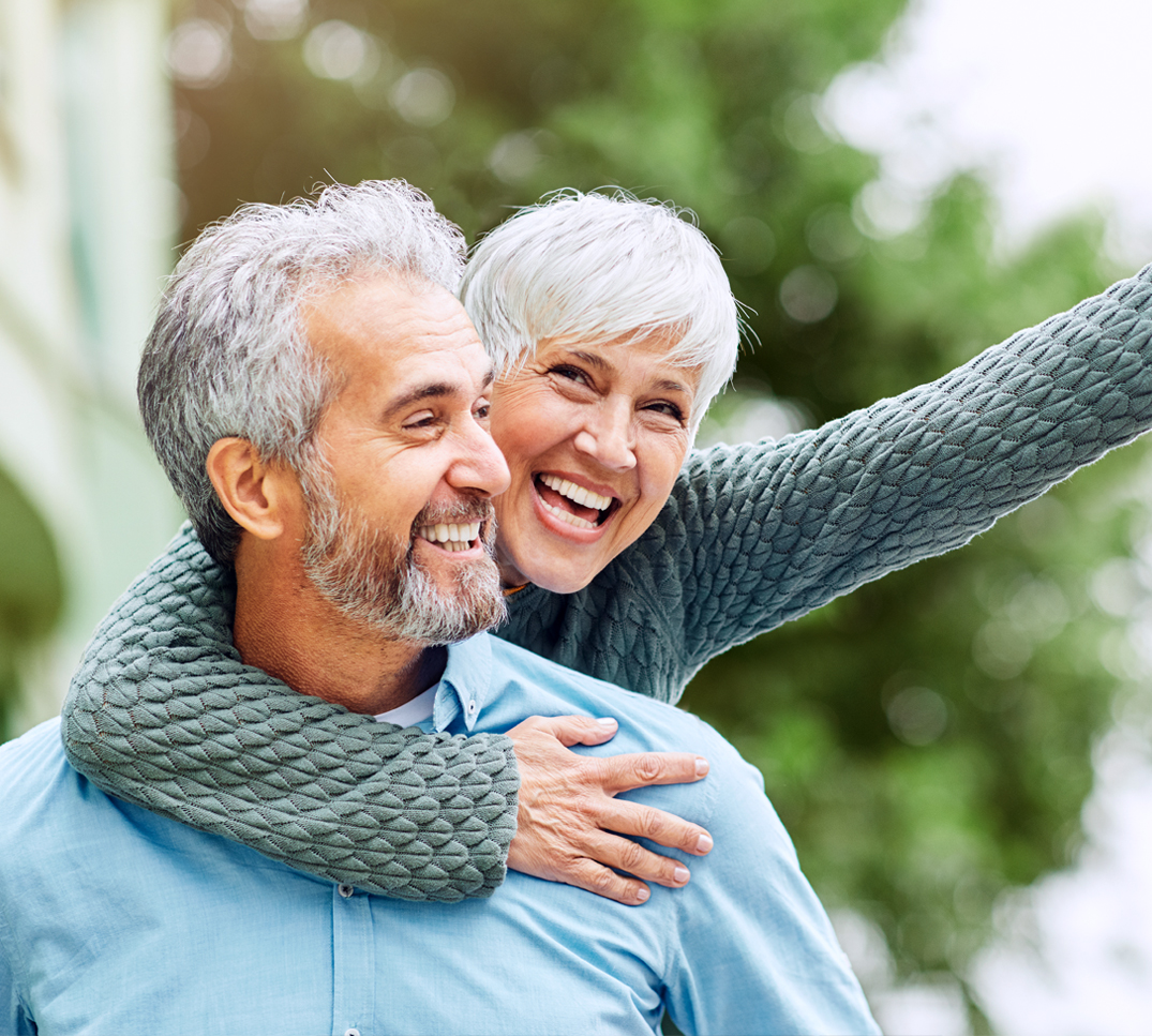 Une personne porte une autre personne à l’extérieur. L’image symbolise une protection fiable et des conseils en assurance adaptés aux différentes étapes de la vie.