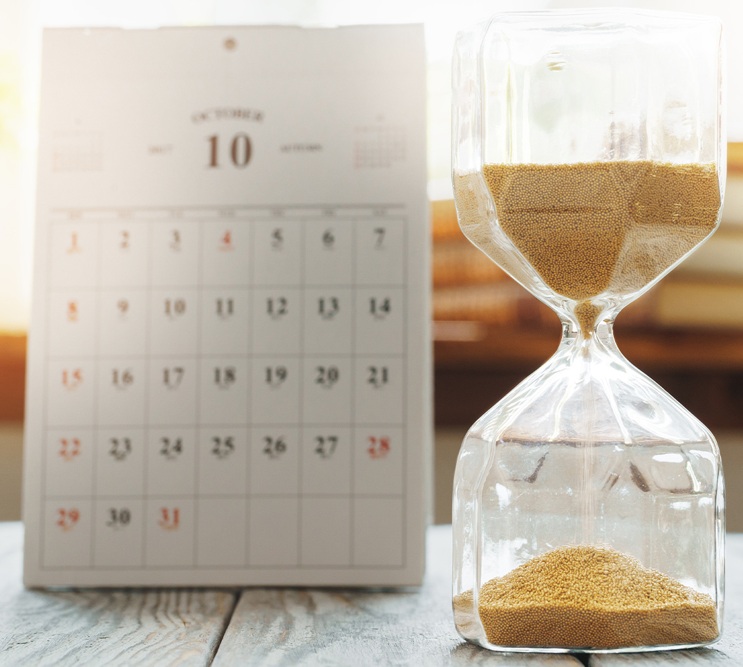 Ein Kalender und eine Sanduhr symbolisieren die kritischen Minuten nach einem Zahnunfall. Innerhalb von 30 Minuten sind die Erfolgschancen am höchsten.